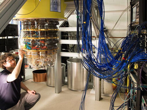 A google quantum computer with lots of blue cables connecting to it.